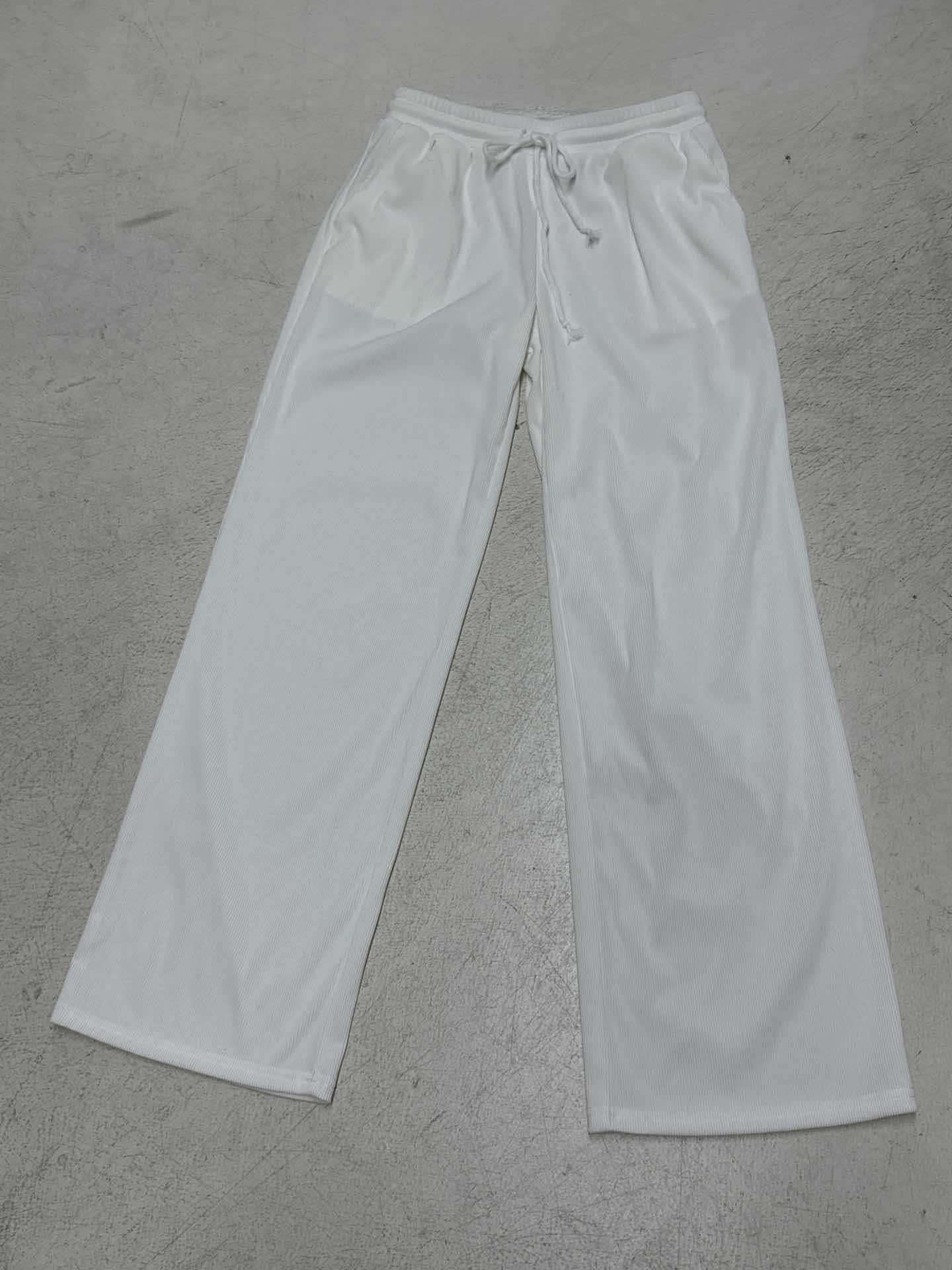 White sweatpants on a gray concrete floor