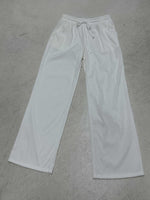 White sweatpants on a gray concrete floor
