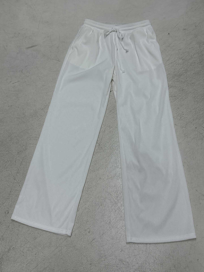 White sweatpants on a gray concrete floor