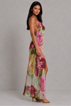 Woman wearing a floral dress against a plain background