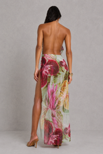 Woman wearing a floral maxi skirt on a plain background