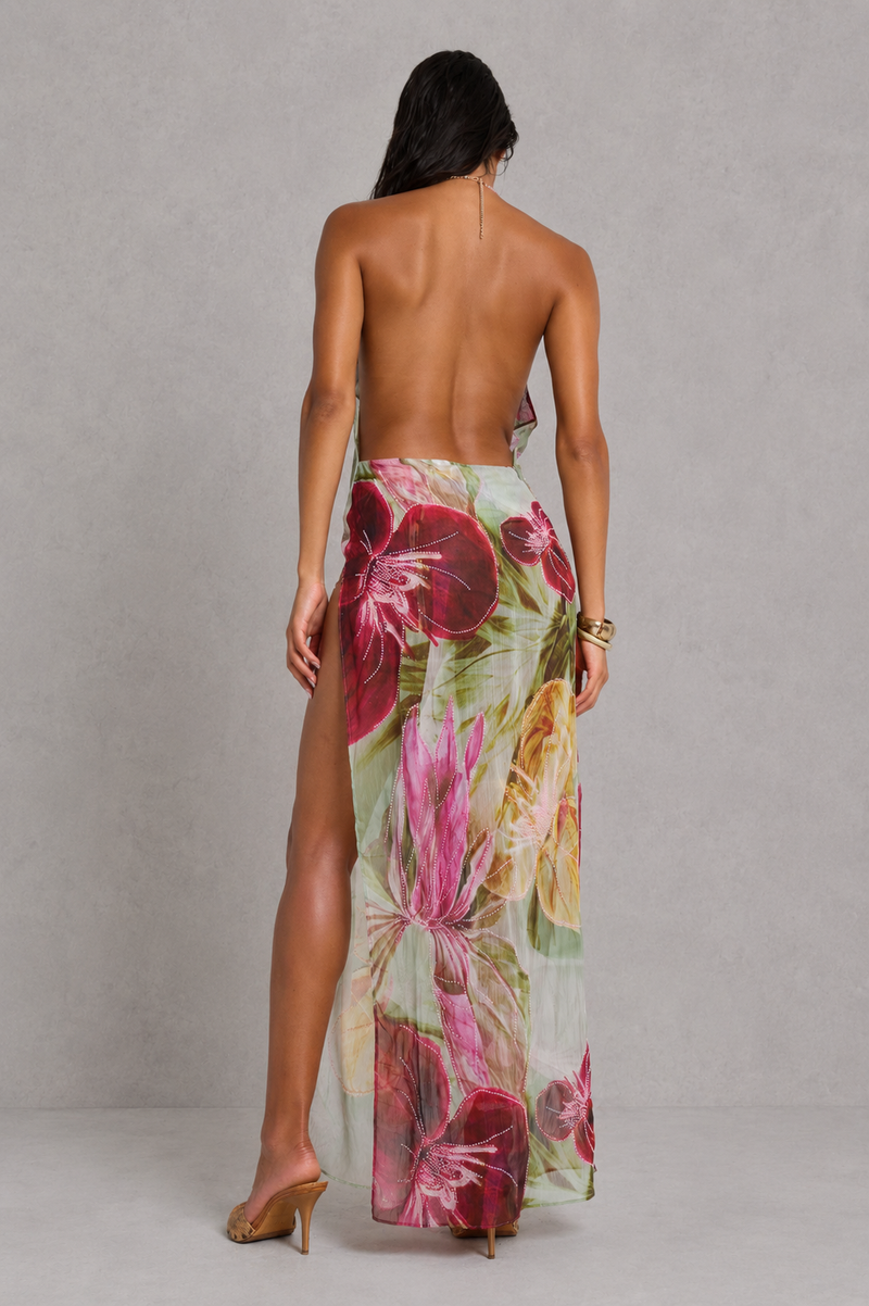 Woman wearing a floral maxi skirt on a plain background