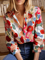 Woman wearing a colorful floral blouse with a blurred background