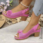 Pink sandals with floral decorations on a neutral background