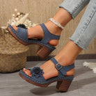 Blue sandals with brown soles worn by a person, with a blurred background