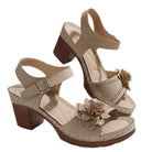 Beige high-heeled sandals with floral decorations on a white background