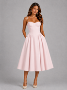 Woman wearing a pink dress against a gray background