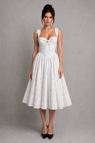 Woman wearing a white dress against a gray background