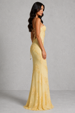 Woman wearing a yellow evening gown with a gray background