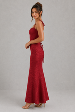 Woman wearing a red evening gown against a gray background