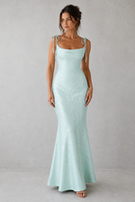 Woman wearing a light blue dress against a gray background
