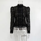 Black lace top on a mannequin against a white background