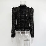 Black lace top on a mannequin against a white background