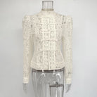 White lace blouse on a mannequin against a gray background