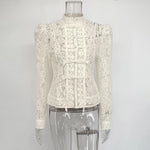 White lace blouse on a mannequin against a gray background