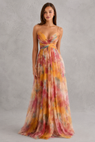 Woman wearing a colorful floral dress against a gray background