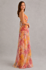 Woman wearing a colorful floral dress on a gray background