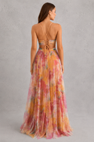 Woman wearing a colorful floral dress with a gray background