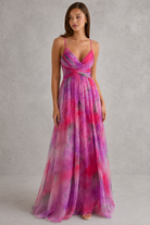 Woman wearing a vibrant, multicolored dress against a plain background