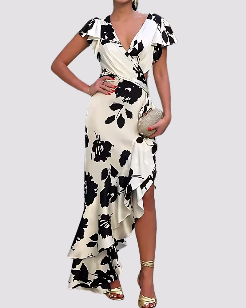 Woman wearing a black and white floral dress on a plain background