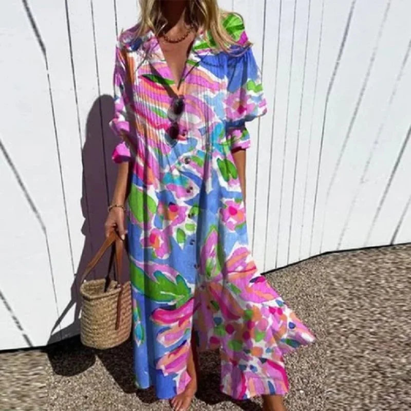 Woman wearing a colorful floral dress against a white wall.