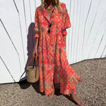 Person wearing a red patterned dress holding a straw bag against a white wall.