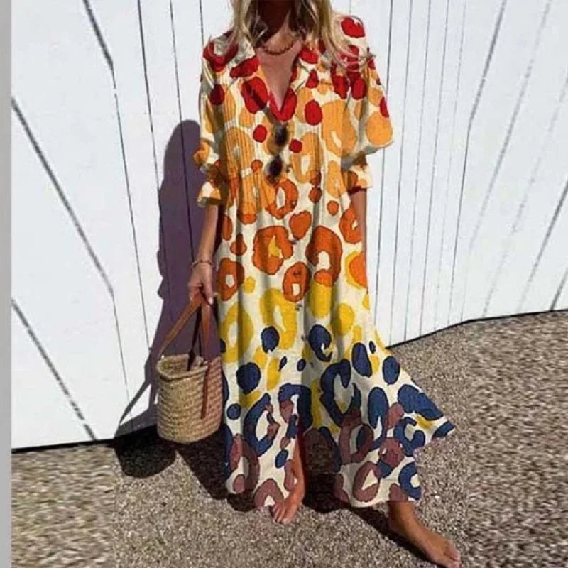 Woman wearing a colorful patterned dress against a white wooden fence.