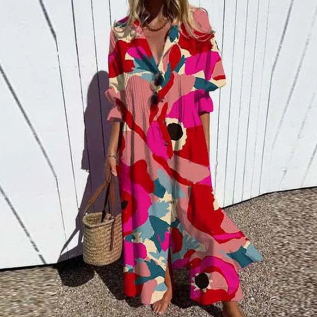 Woman wearing a colorful patterned dress against a white wall.