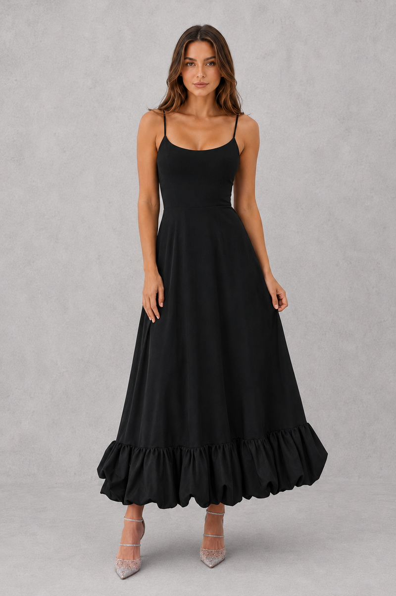 Woman wearing a black dress with ruffled hem on a gray background