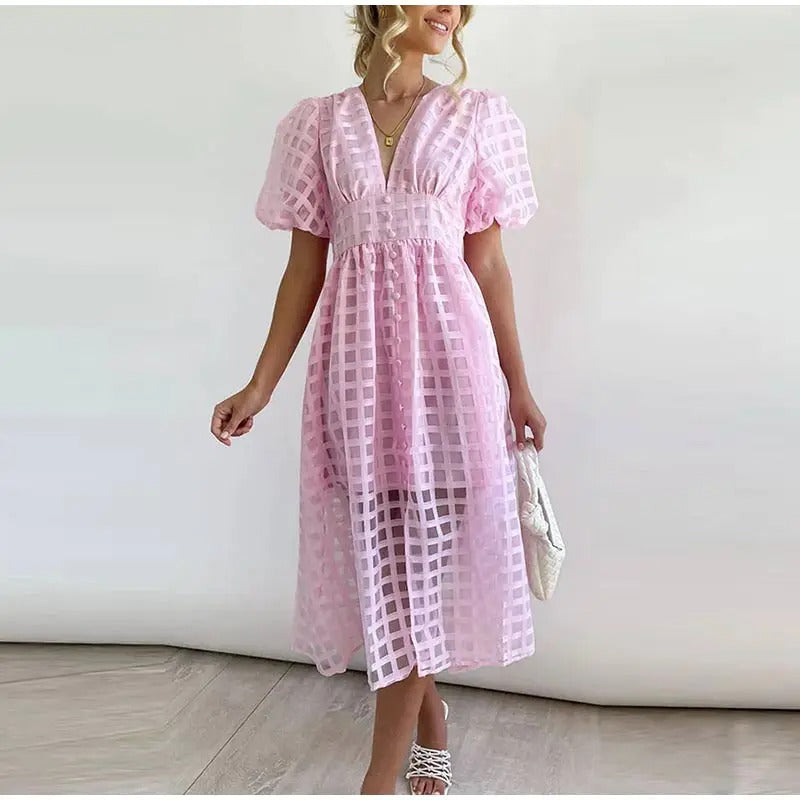Woman wearing a pink checkered dress against a white background