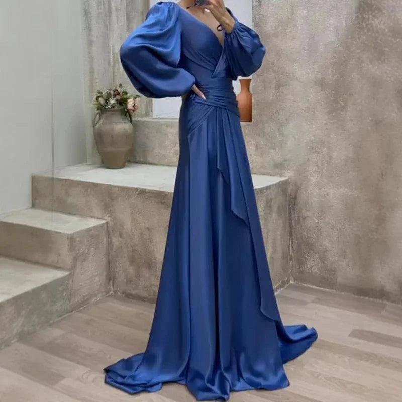 Woman wearing a blue evening gown in an indoor setting.