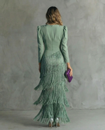 Woman wearing a green dress with a textured pattern against a gray background