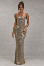 Woman wearing a sparkly strapless gown against a neutral background