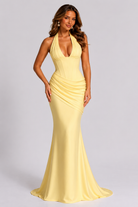 Woman wearing a yellow evening gown on a gray background