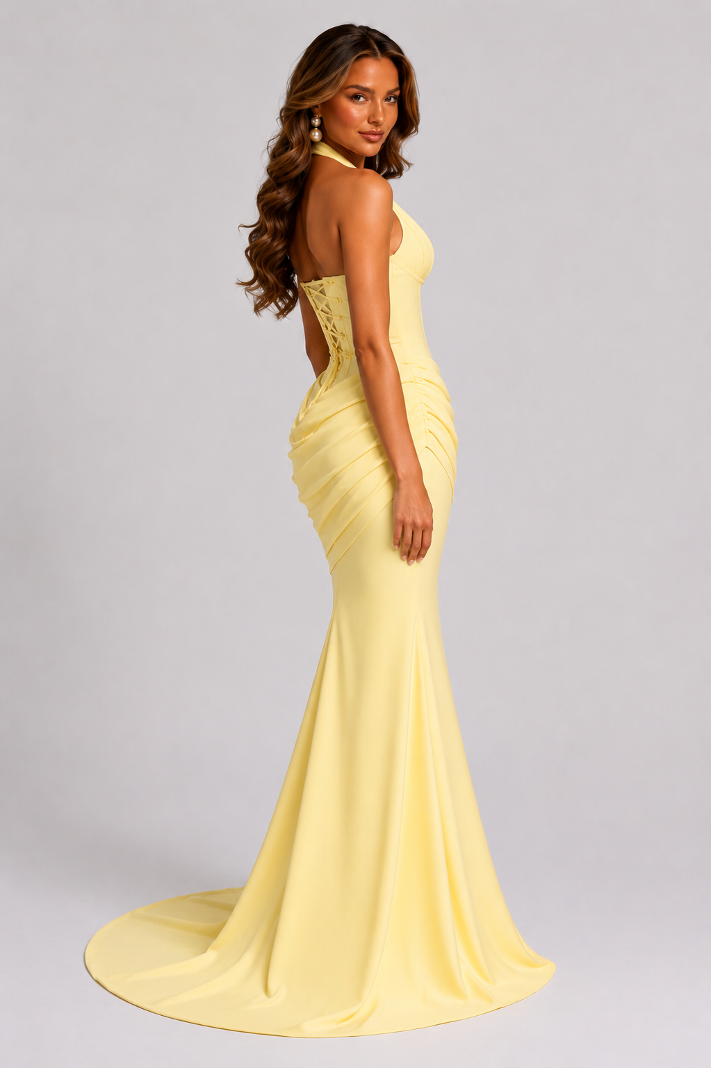 Woman wearing a yellow evening gown on a gray background