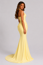 Woman wearing a yellow evening gown on a gray background