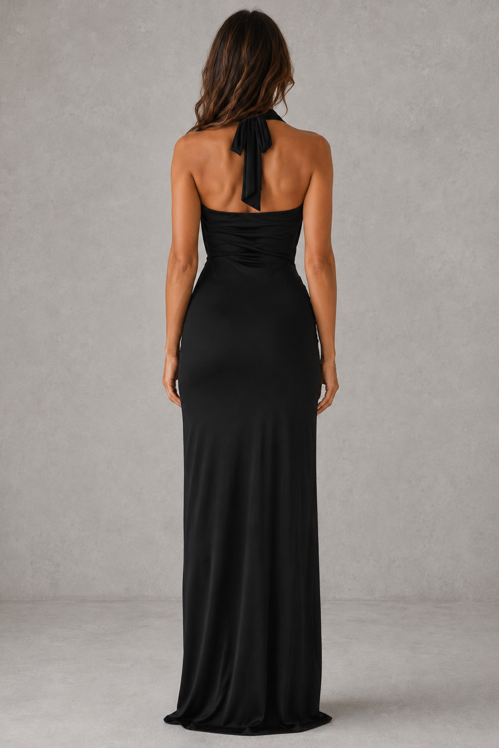 Woman wearing a black halter neck gown against a gray background