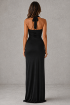 Woman wearing a black halter neck gown against a gray background
