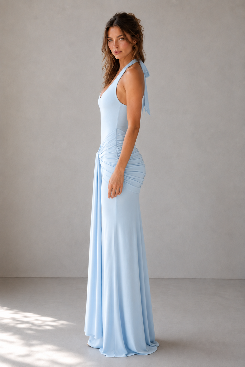 Woman wearing a light blue dress against a plain background
