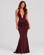 Woman wearing a burgundy evening gown on a gray background