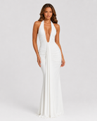 Woman wearing a white halter neck gown on a plain background