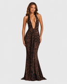 Woman wearing a leopard print halter neck gown on a light gray background