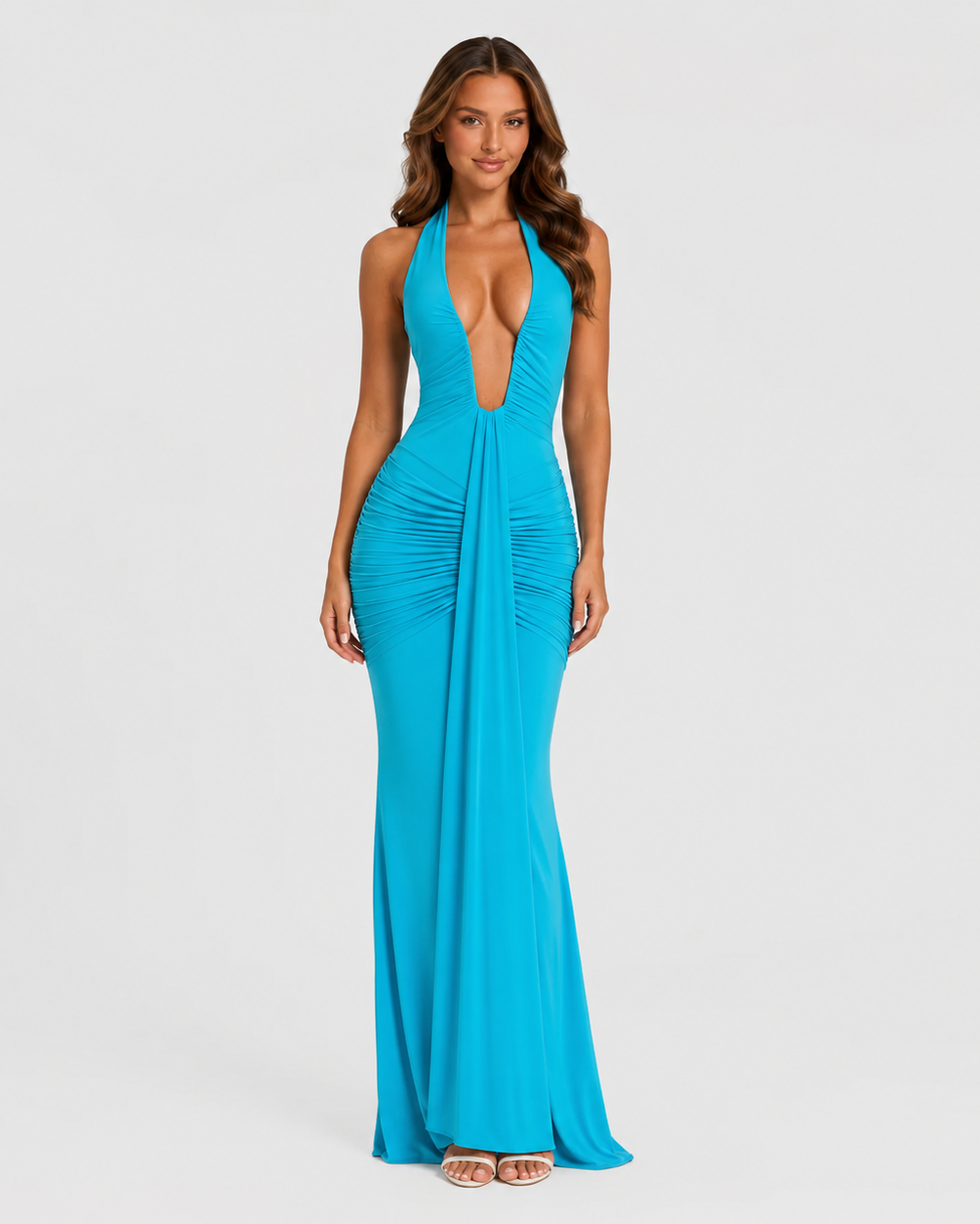 Woman wearing a turquoise halter neck gown on a light gray background