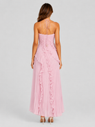 Woman wearing a pink dress with ruffled details on a gray background