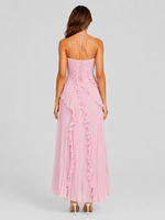 Woman wearing a pink dress with ruffled details on a gray background