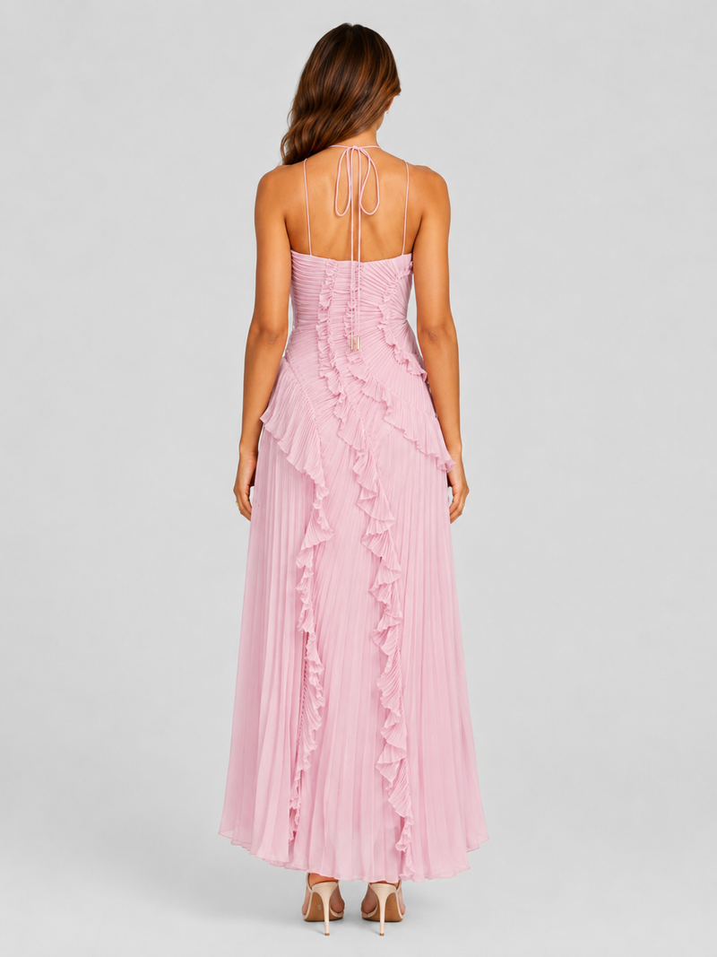Woman wearing a pink dress with ruffled details on a gray background