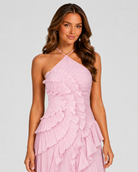 Woman wearing a pink ruffled dress against a gray background