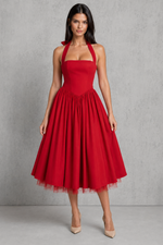 Woman wearing a red dress against a gray background.