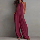 Maroon jumpsuit worn by a model against a neutral background