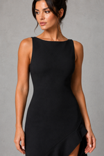 Woman wearing a black sleeveless dress against a gray background